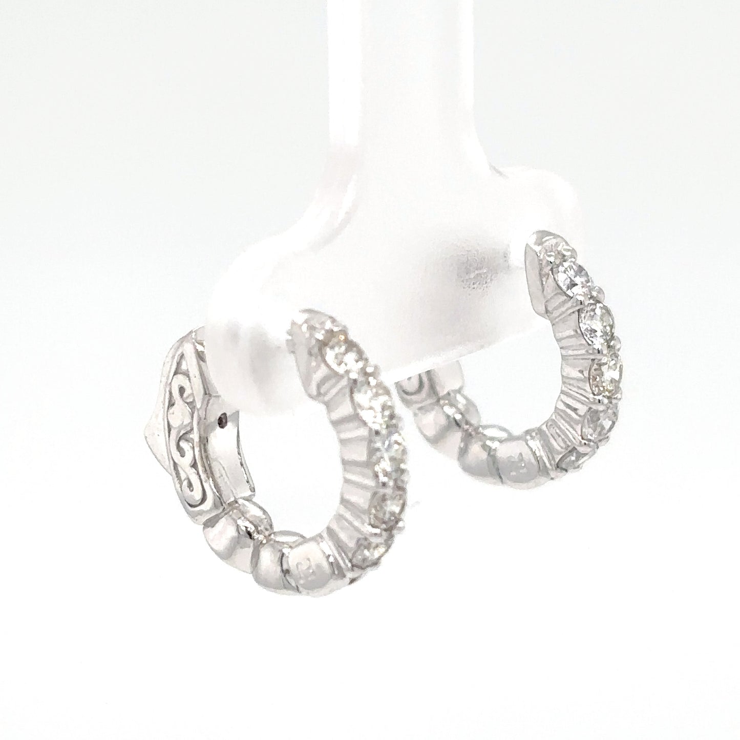 Silver hoop earrings with intricate designs on a white background