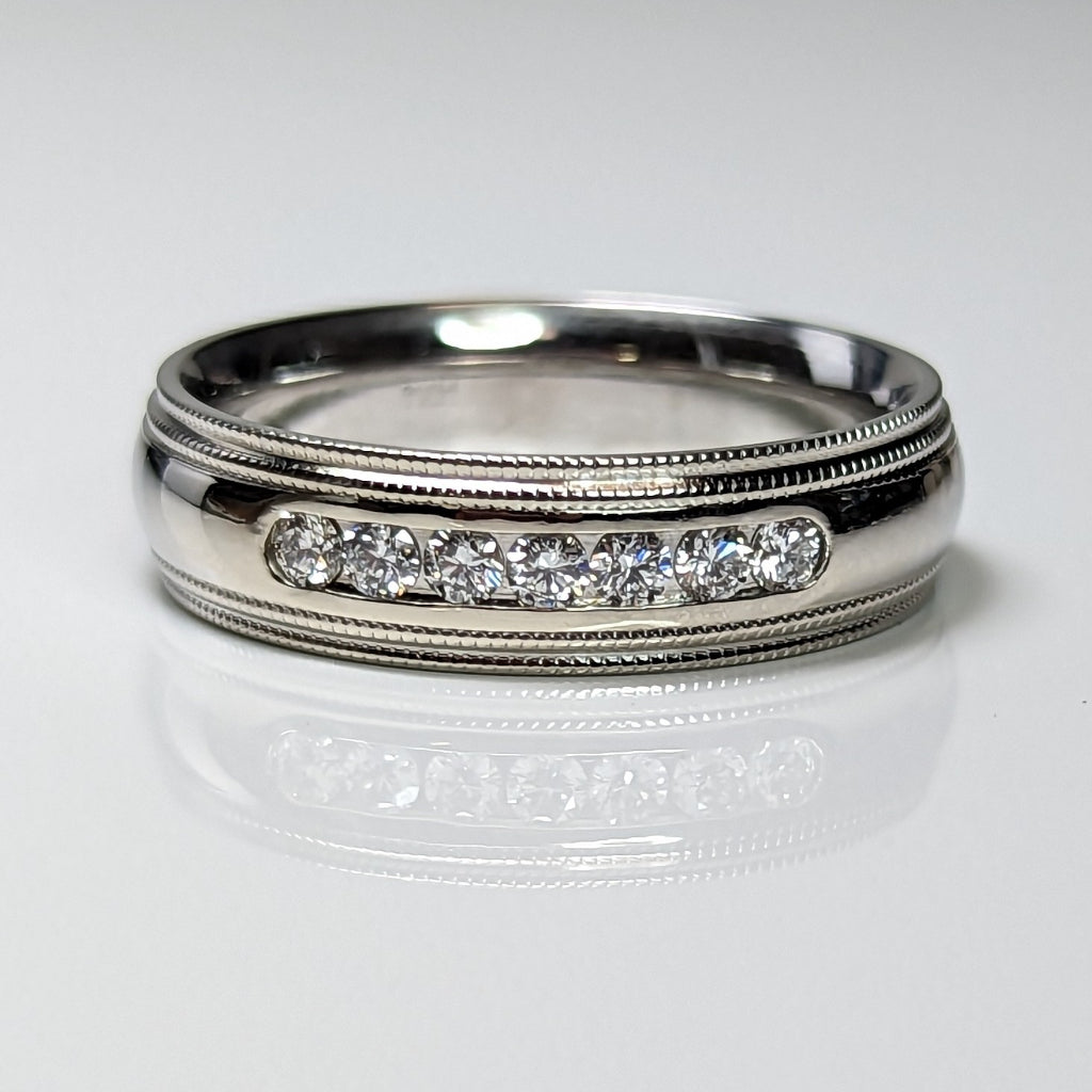 Silver ring with diamond accents on a white background