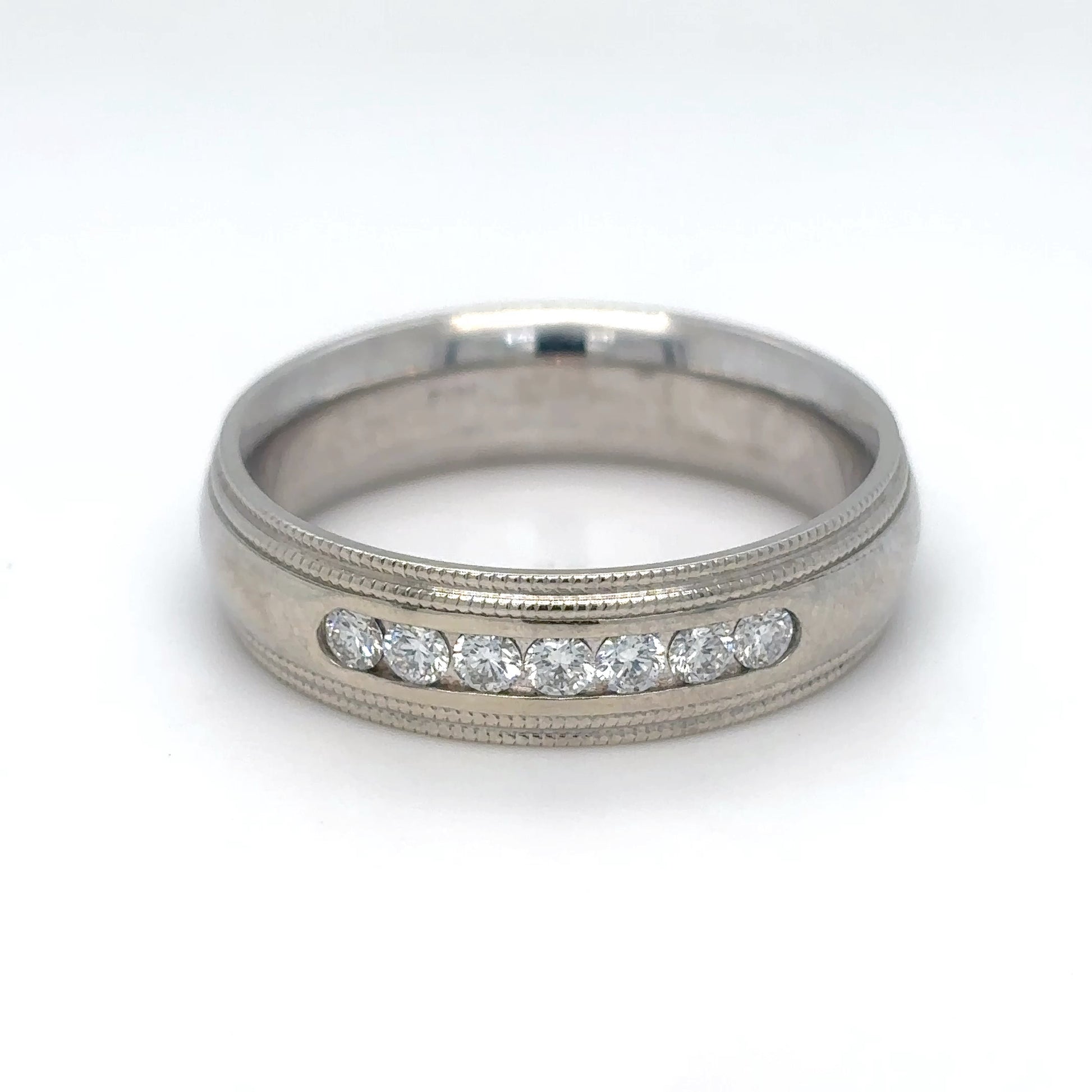 Silver ring with embedded diamonds on a white background
