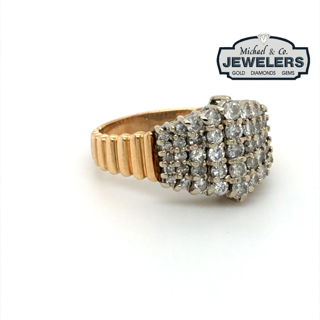 Gold ring with diamond cluster on a white background, branded with Michael & Co. Jewelers.