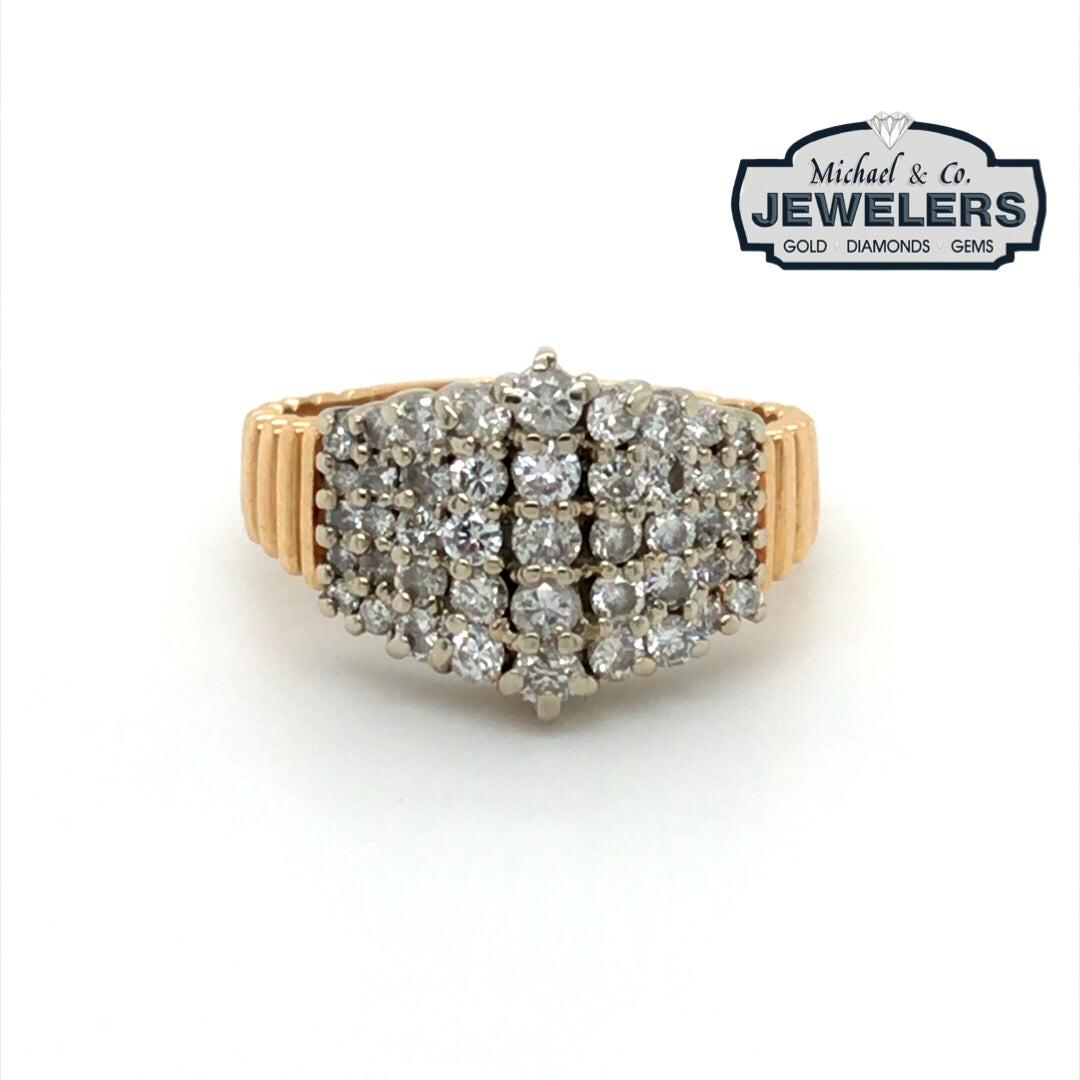 Gold ring with diamonds on a white background, branded with Michael & Co. Jewelers.