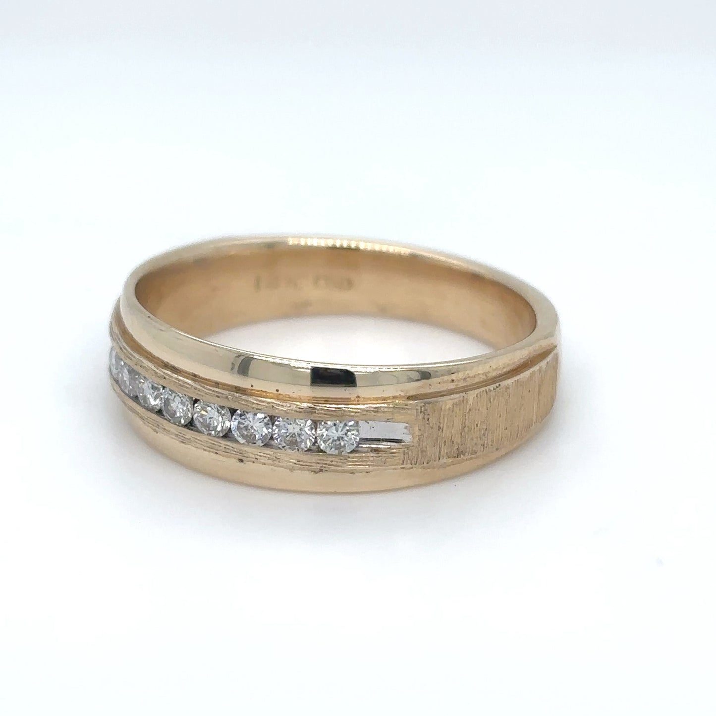 Gold ring with diamond accents on a white background