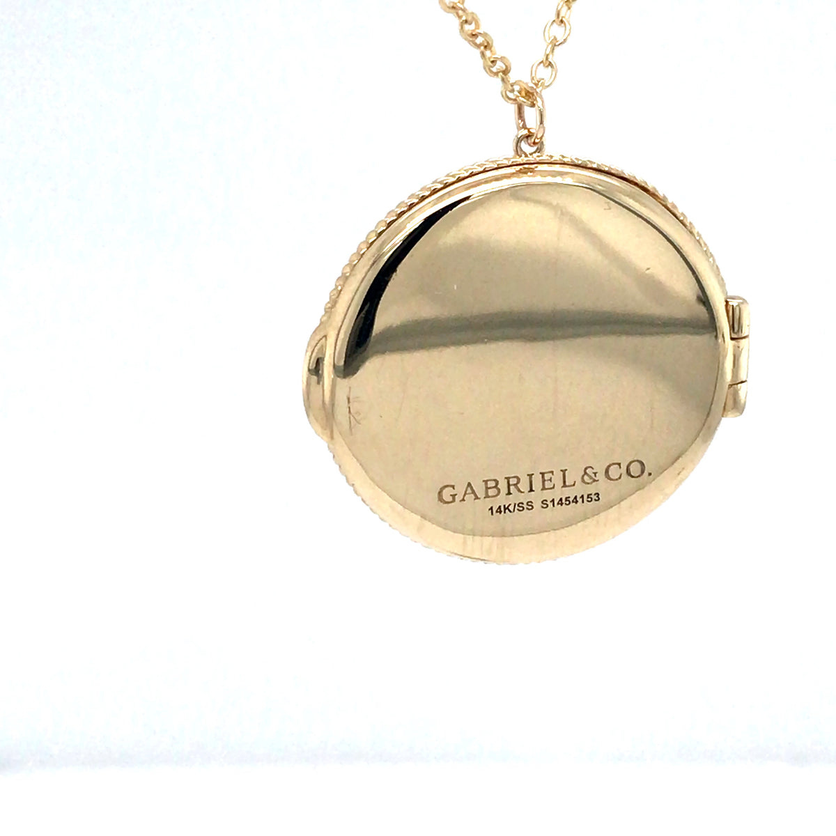 Gold locket with 'Gabriel & Co.' engraving on a white background