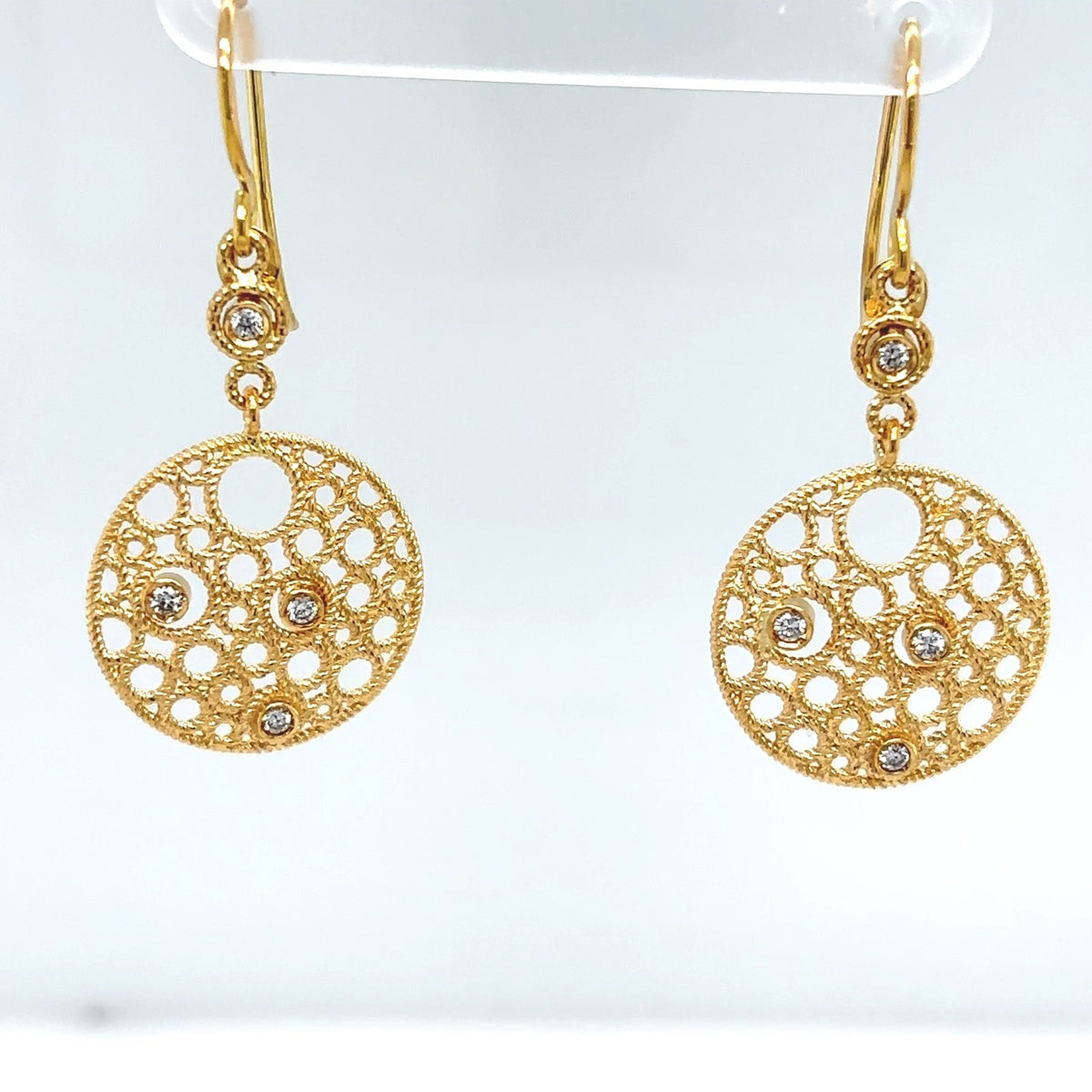 Gold earrings with intricate designs on a white background