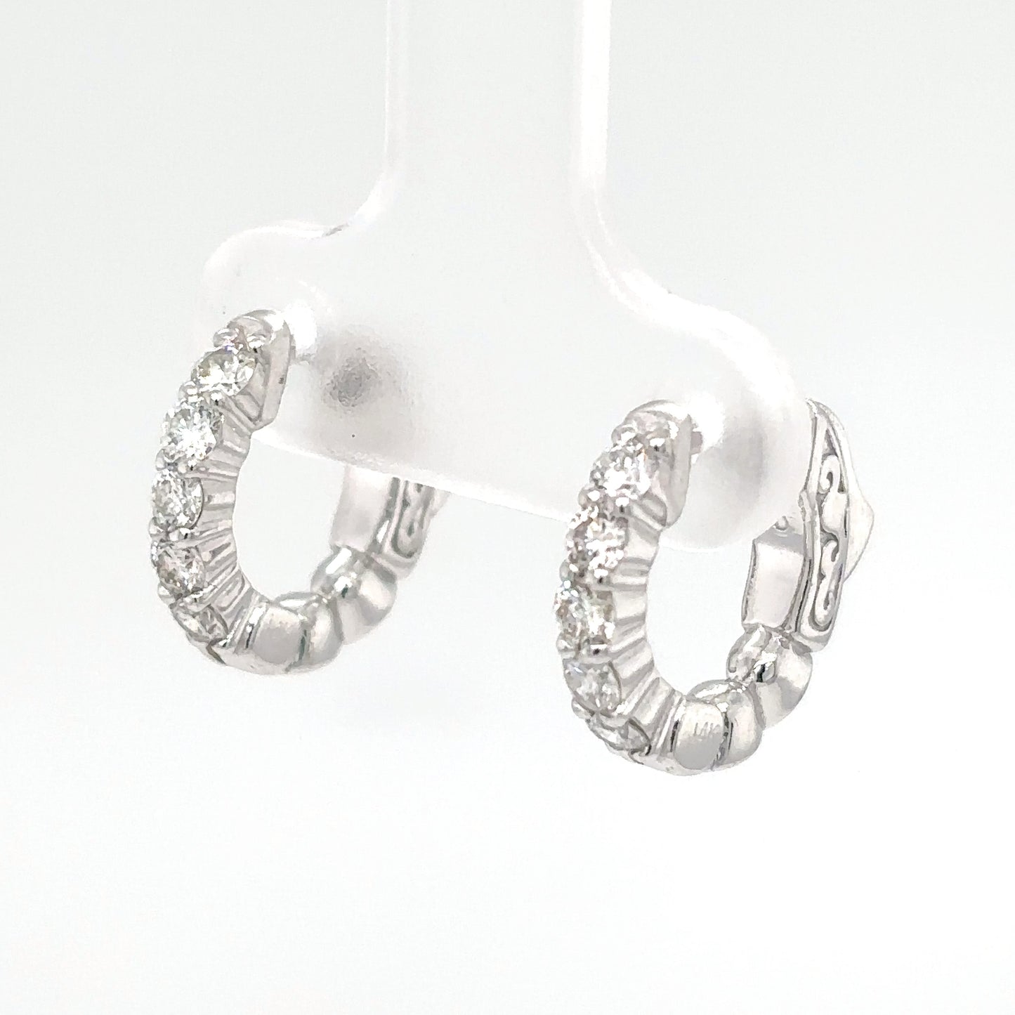 Pair of silver hoop earrings with clear gemstones on a white background