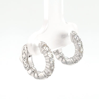 Silver hoop earrings with intricate designs on a white background