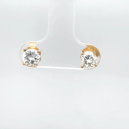 Pair of gold earrings with clear gemstones on a white background