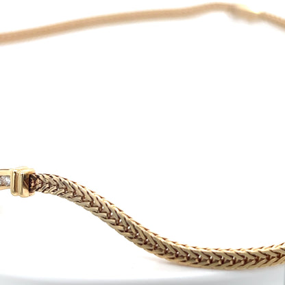 Gold bracelet with braided design on a white background