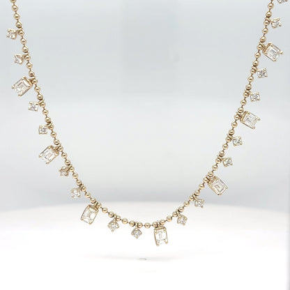 A 14K yellow gold necklace with alternating emerald-cut and round brilliant diamonds, displayed against a white background.