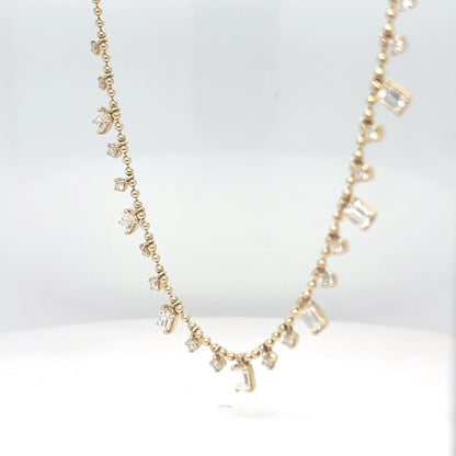 A delicate 14K yellow gold chain necklace set with emerald-cut and round brilliant diamonds, displayed against a white background.