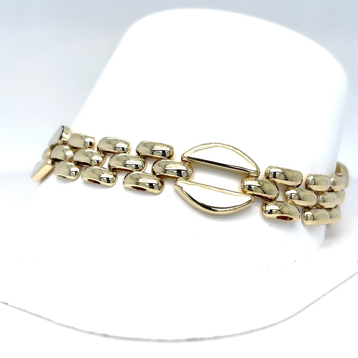 Gold bracelet on a white earring stand